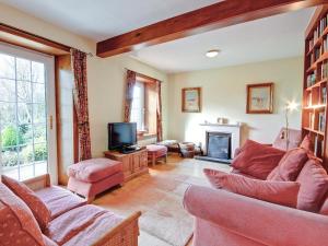 a living room with two couches and a tv at The Cottage in Girvan