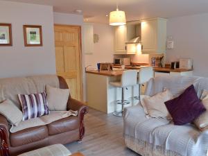 a living room with two couches and a kitchen at Woodview Lodge in Barlow