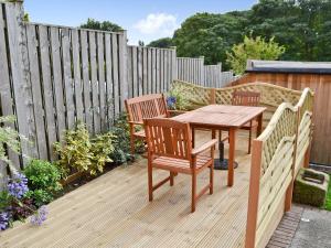 un tavolo e sedie in legno su una terrazza di legno di Woodview Lodge a Barlow