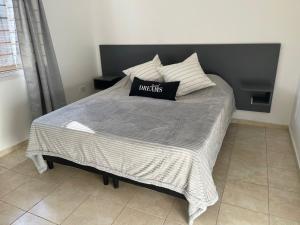 Una cama con un cabecero negro y una almohada encima. en Departamentos Alberdi 1, en San Rafael