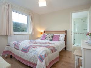 Schlafzimmer mit einem Bett und einem Fenster in der Unterkunft Challette At Timbertops in Washfield
