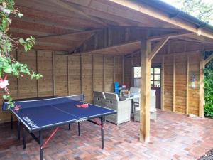 a patio with a ping pong table in a pavilion at Challette At Timbertops in Washfield