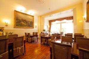 une salle à manger avec des tables et des chaises ainsi qu'une peinture murale. dans l'établissement Hotel Dordrecht, à Dordrecht