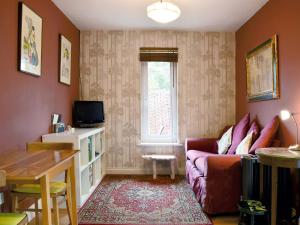 uma sala de estar com um sofá e uma janela em The Writing Room em Barford
