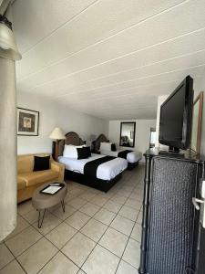 a hotel room with two beds and a flat screen tv at Holiday Isles Resort in St. Pete Beach