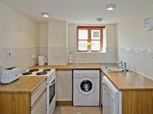 een keuken met een wasmachine en een wastafel bij Barrowmead Cottage - E2377 in Banwell