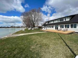 een gebouw met een terras naast een waterlichaam bij Beach House in Niagara in Wainfleet