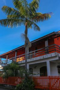 a building with a palm tree in front of it at Pousada entre Paraísos in Angra dos Reis