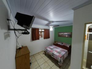 um quarto com uma cama e uma televisão de ecrã plano em Pousada entre Paraísos em Angra dos Reis