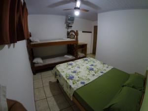 a small bedroom with a bed and a small table at Pousada entre Paraísos in Angra dos Reis