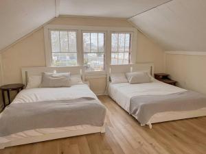 twee bedden in een kamer met twee ramen bij Beach House in Niagara in Wainfleet