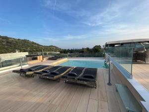 una terraza con tumbonas y una piscina en Crabonaxa Suite Appartment en Villasimius