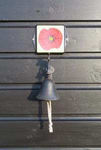 um sino com uma flor pendurado numa parede em Vakantiewoning De Klaproos em Boyl