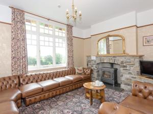 a living room with a couch and a fireplace at Neuadd Las in Tregaron