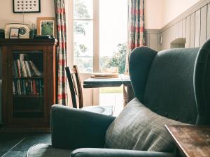 a living room with a chair and a table at Southfield Cottage in Braunston