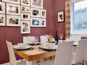 comedor con mesa de madera y sillas blancas en Torr Caladh en Glenfinnan