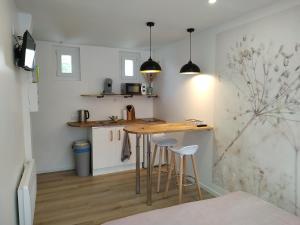 eine kleine Küche mit einem Holztisch und Stühlen in der Unterkunft Studio Flore, à 5 min du centre in Arras