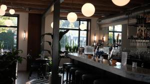 a bar with a counter and some chairs and windows at Café Koophandel in Ouddorp