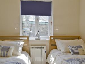 ボウネス・オン・ウィンダミアにあるLow Riggのベッドルーム1室(ベッド2台付)、窓(青いブラインド付)