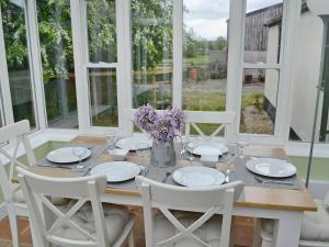 jadalnia ze stołem, krzesłami i oknami w obiekcie Pond-b6844 w mieście Sedghill