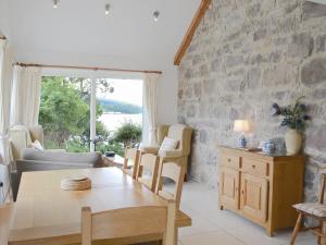 a living room with a table and a stone wall at Cruary in Applecross