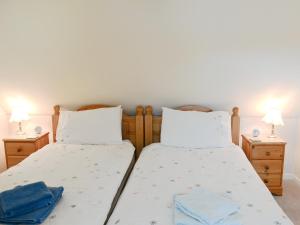 two twin beds in a bedroom with two lamps at Cruary in Applecross