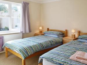 a bedroom with two beds and a window at Corney Grain in Teversham