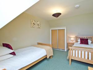 a bedroom with two beds and a window at The Hayloft - SNNL in Carnwath