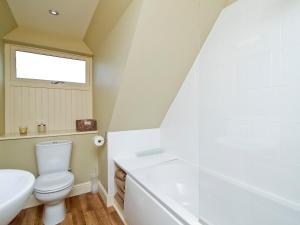 a bathroom with a toilet and a tub and a sink at The Hayloft - SNNL in Carnwath