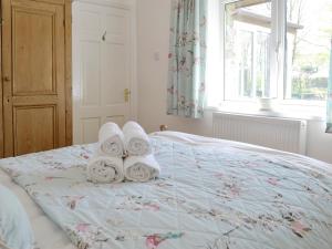 a bedroom with a bed with towels on it at The Garden Cottage in Wrangaton