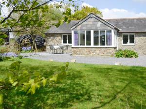 a stone house with a lawn in front of it at The Garden Cottage in Wrangaton