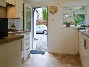 een keuken met een klok aan de muur naast een deur bij Fairholme in Braithwaite