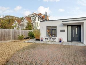 Biały dom z czarnymi drzwiami i patio w obiekcie Solsken w Bournemouth