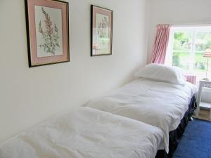 two twin beds in a room with two pictures on the wall at Mill Cottage in Rievaulx