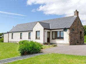 a white house with a stone building at Ach-na-clachan in Gairloch