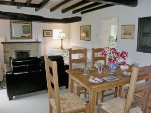 a living room with a wooden table and chairs at Mill Cottage in Rievaulx