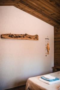 a log hanging on a wall next to a bed at Posada Los Cipreses in San Rafael
