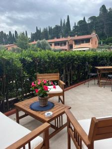 a patio with chairs and a table with flowers on it at Isolotto Guest House in Porto Ercole