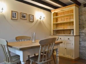 a dining room with a wooden table and chairs at Dale End Cottage in Brassington