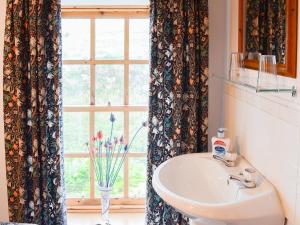 ein Bad mit einem Waschbecken und einem Fenster in der Unterkunft Stable Cottage in John O Groats
