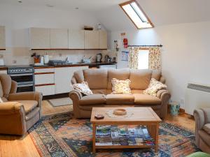 a living room with a couch and a table at Stable Cottage in John O Groats