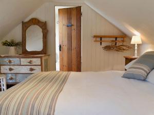 Un dormitorio con una gran cama blanca y una escalera en Om Shanti - 28602, en Tipton Saint John