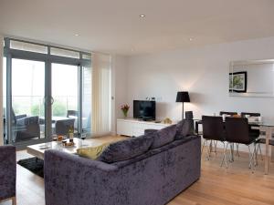 a living room with a couch and a dining room at Fistral View - 3 Cribbar in Newquay