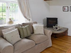 sala de estar con sofá y chimenea en Wee Bridge Farm Cottage, en Mobberley