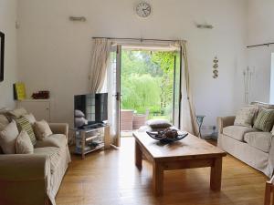 sala de estar con sofá y mesa de centro en Wee Bridge Farm Cottage, en Mobberley