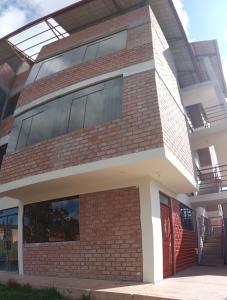 a building with a red brick at Maychu's Albergue in Chincheros