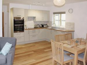 a kitchen and dining room with a table and chairs at Bodwen Corner Cottage in Wootton Bridge