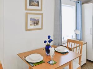 a dining room table with a vase of flowers on it at Learig Cottage in Maidens