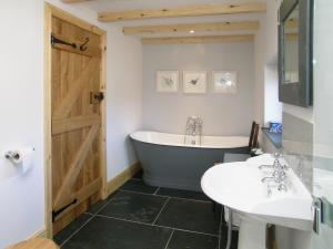 ein Badezimmer mit einer Badewanne, einem WC und einem Waschbecken in der Unterkunft The Cart House in Milford