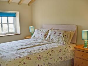 a bedroom with a bed and a window at Honeypot Cottage in Saint Cross